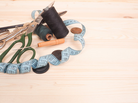 Sewing accessories in a wood background. sewing concept.