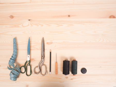 Sewing accessories in a wood background. sewing concept.