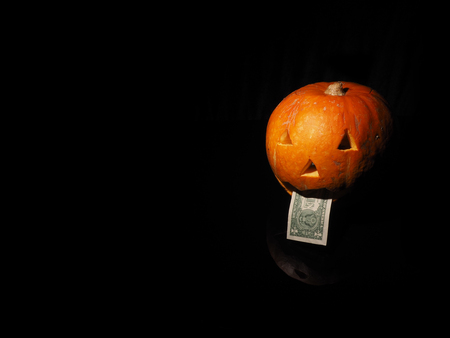 Halloween pumpkin with dollar on the black background.の写真素材