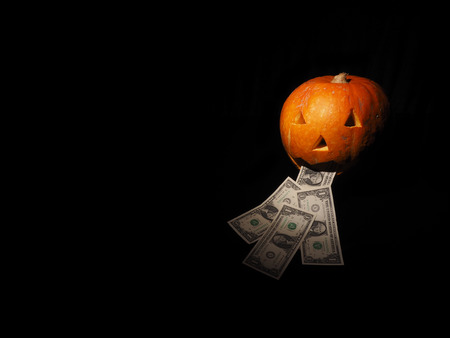 Halloween pumpkin with dollar on the black background.の写真素材
