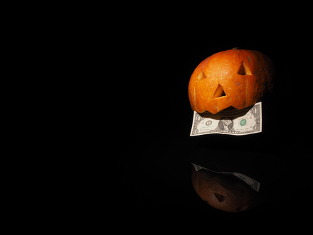 Halloween pumpkin with dollar on the black background.の写真素材