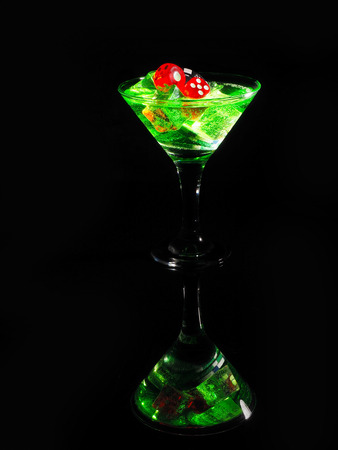 Red dice in a cocktail glass on black background. casino series.の写真素材