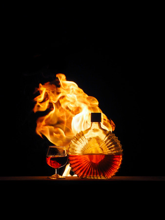 Cognac with a fire on a black background.の写真素材