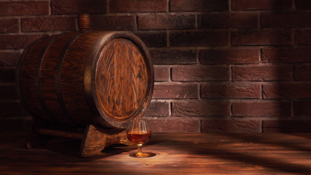 Glass of cognac with barrel on wooden table.の写真素材