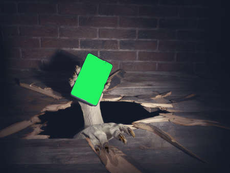 Zombie hand through hole cracked in rustic wood.Halloween theme.の写真素材