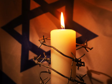 Flag of Israel, barbed wire and burning candle on black background. Holocaust memory dayの写真素材