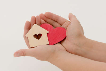 close-up top view of the palms in which the heart and the house lie. Horizontal photo.の写真素材