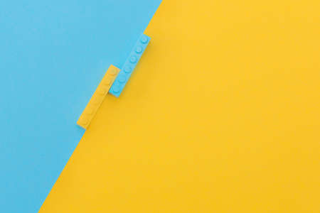 two small rectangular constructors in yellow and blue, lie on a yellow and blue background. Color contrast. Concept - Background, layout for advertising, place for textの写真素材