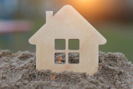 silhouette, shape in the form of a house on a pile of sand and blurred background. Concept - buying, selling real estate, mortgage, affordable housing. Horizontal photo, close-upの写真素材