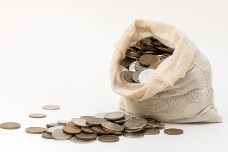 open bag with Russian coins stands on a white background. Lots of cash. Concept - saving money, saving money for a rainy day. Horizontal photoの写真素材