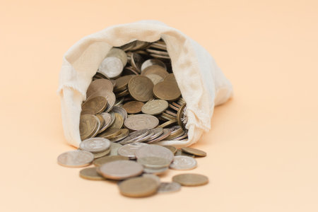 from a small bag on a beige background, Russian coins poured out. Horizontal photo. Big planの写真素材