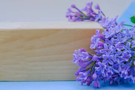 close-up of a wooden board, near beautiful flowers of lilac. Place for text, lettering. Frame. Soft focus.copy space. Festive background for projectsの写真素材