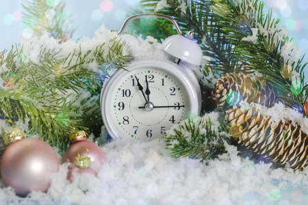 the white clock shows five minutes to midnight. The alarm clock will stand in the snow, against the...