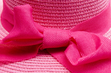 woven hat with a pink ribbon sun in the background.の写真素材