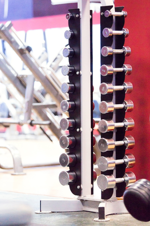 Fit barbell and dumbbells in the gym. Close up of many dumbell in sport fitness centre, equipment diversityの写真素材