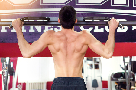 Close up of young bodybuilder training in the gym. Sport concept