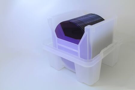 Empty silicon wafers purple color storage in plastic box, prepared for microchip productionの写真素材