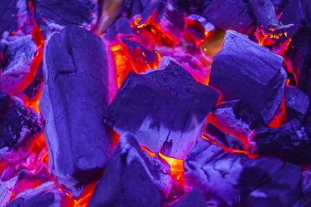 Glowing Hot Charcoal Briquettes Close-up Background Texture.Burning firewood in the fireplace close up. BBQ fire. Charcoal background. Charcoal fire with sparks.の写真素材