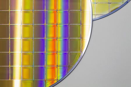 Silicon Wafers with microchips - A wafer is a thin slice of semiconductor material, such as a crystalline silicon pieces of wafers with microchips.Rainbow on silicon wafers.Color silicon wafers with glare.の写真素材