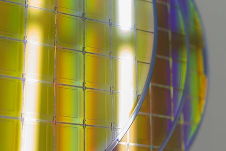 Silicon Wafers with microchips - A wafer is a thin slice of semiconductor material, such as a crystalline silicon, used in electronics for the fabrication of integrated circuits.Several pieces of wafers with microchips.の写真素材