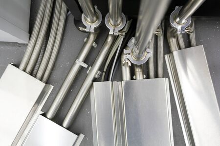 Fragment of a complex connection of many steel tubes and wires between various communication and...