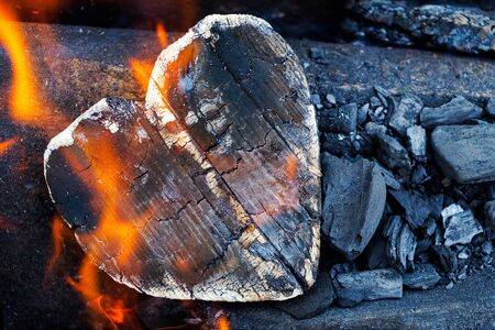 Hot coals and burning woods in the form of human heart. Glowing and flaming charcoal, bright red fire and ash. .Close-up.の写真素材