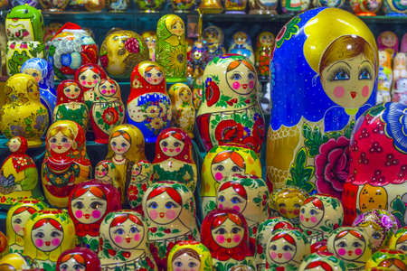 A lot of Matryoshka at souvenir market shop. Different colors Russian dolls. Traditional classic Russian handicraft art background. Famous classical and modern Russian dolls Matryoshka toysのeditorial素材