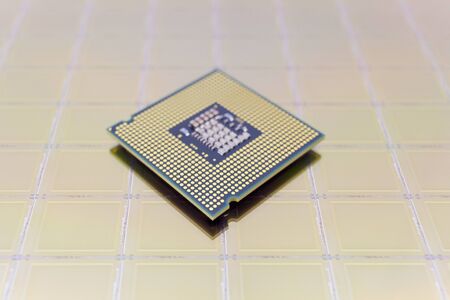 Photo of a Computer Chip CPU put on silicon wafer with microchip gold colorの素材 [FY310146114630]