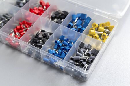 Tips of different sizes and colors for crimping stranded electrical wires. Wire tips in the plastic...