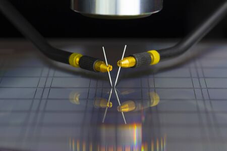Manual probe system with needles for test of semiconductor on silicon wafer. Selective focus.