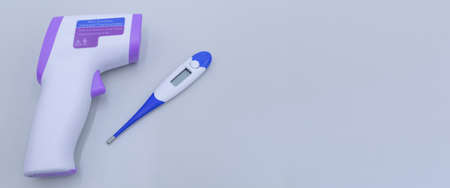 Non-contact infrared thermometer on grey background to measure a body temperature. Healthcare and...