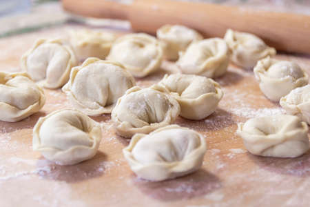 Uncooked Russian Pelmeni on Wood desk Background Homemade Pelmeni Ravioli or Dumplings.