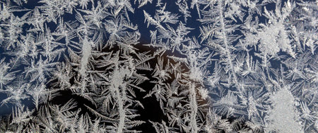 Melting ice running down a window pane,