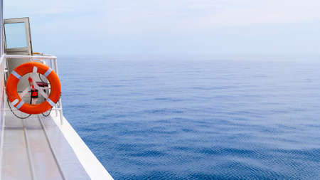 Railing on Cruise Ship with red Lifebelt and calm Sea in the Sunの写真素材