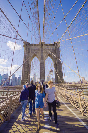 People walking over beautiful Brooklyn Bridge in New York- MANHATTAN / NEW YORK - APRIL 1, 2017のeditorial素材