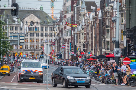 The busy street of Damrak in Amsterdam - very popular all day - AMSTERDAM - THE NETHERLANDS - JULY 20, 2017のeditorial素材