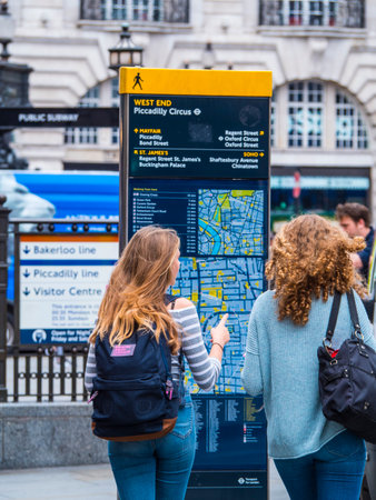 Young girls searching for directions on a London Mapのeditorial素材