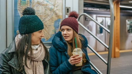 Two girls sit in a New York subway train - NEW YORK, UNITED STATES - DECEMBER 4, 2018のeditorial素材