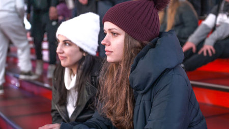 Two girls at Times Square by night sit on the famous red steps - NEW YORK, UNITED STATES - DECEMBER 4, 2018のeditorial素材