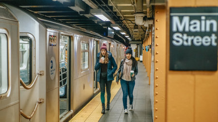 Two women on a platform of a New York subway station wait for their train - NEW YORK, UNITED STATES - DECEMBER 4, 2018のeditorial素材