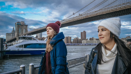 Two friends travel to New York for sightseeing at Brooklyn Bridge - NEW YORK, USA - DECEMBER 4, 2018のeditorial素材
