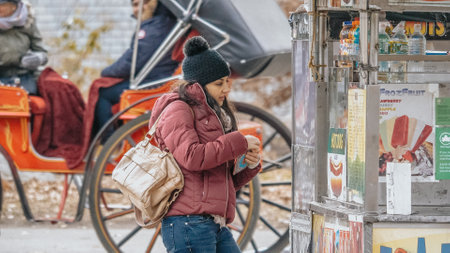 Young woman buys a hot dog in the streets of New York - NEW YORKのeditorial素材