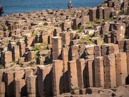 Visitors at Giants Causeway in Northern Ireland - BUSHMILLS. NORTHERN IRELAND - MAY 12, 2019のeditorial素材