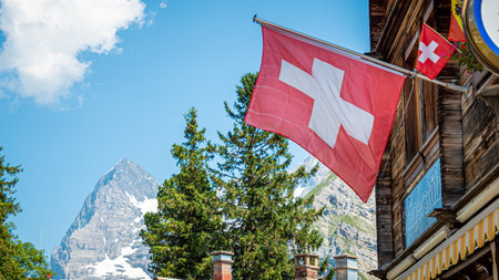Swiss flag attached to a wooden hut in Switzerland - SWISS ALPS, SWITZERLAND - JULY 22, 2019のeditorial素材