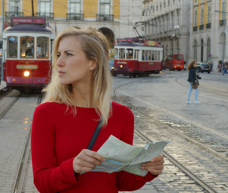 Attractive woman checks directions on the map om the city of Lisbon - CITY OF LISBON, PORTUGAL - OCTOBER 15, 2019のeditorial素材