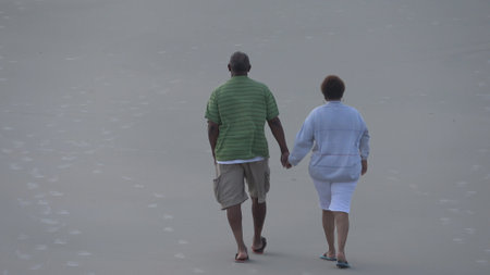 Old couple walking at the beach - DAYTONA BEACH, USA APRIL 14, 2016 - travel photographyのeditorial素材