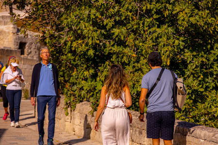 Tourists walk through the historic district of Matera in Italy - a famous landmark and filming location - MATERA, ITALY - OCTOBER 30, 2021のeditorial素材