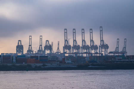 The cranes at the Port of Hamburg on a misty day - CITY OF HAMBURG, GERMANY - DECEMBER 21, 2021のeditorial素材