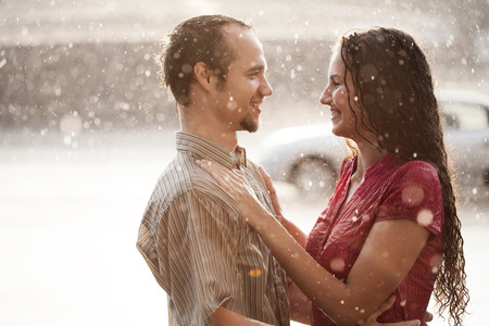 Love in the rain. Boy and a girl kissing in the rainの写真素材