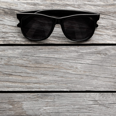 Eyeglasses Glasses with Black Frame Fashion Vintage Style on Wood Desk Background backlit with copy space for text. square imageの写真素材